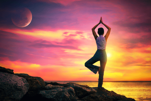Faire du yoga devant un coucher de soleil